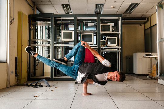Young man breakdancing on floor in abandoned room