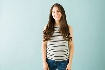 Obraz premium Portrait of a happy young woman in front of a blue background