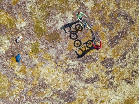 Russia, Murmansk region, Kolsky District, Teriberka, Two men cycling on coastline, aerial view