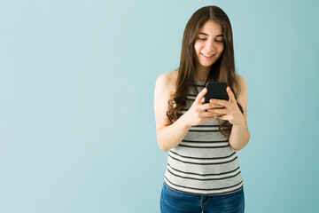 Caucasian woman is happy and sending a text on her smartphone