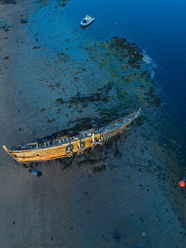 Aerial view of old boat abandoned on coastal beach of&not;&dagger;Barents Sea