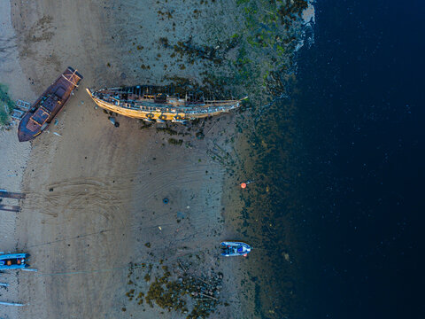 Aerial view of old boats abandoned on coastal beach of&not;&dagger;Barents Sea