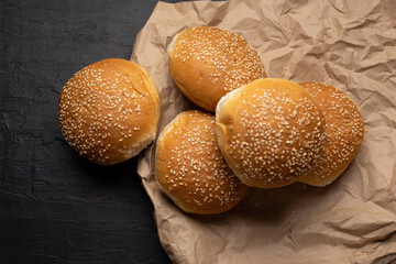 Burger bun bread with sesame seeds on dark background