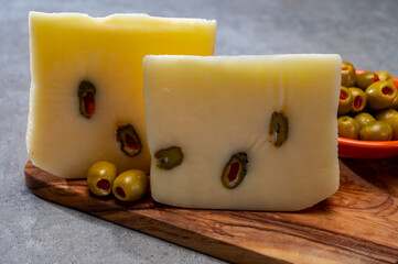 Cheese collection, fresh Italian pecorino cheese made from sheep milk filled with green olives stuffed with red paprika