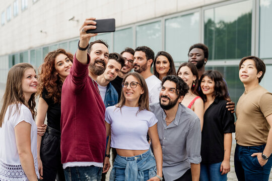 Man taking selfie with group of friends in city