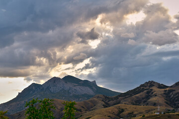 Fototapeta premium Beautiful thick clouds over the peaks of the mountains in the evening