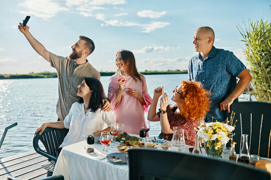 Friends having dinner at a lake taking a selfie