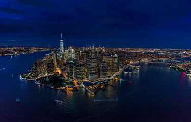 USA, New York, New York City, Manhattan, Aerial view of illuminated skyline with harbor at night