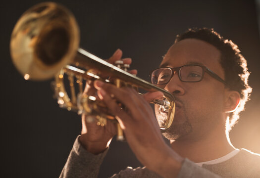 Mid adult man playing trumpet