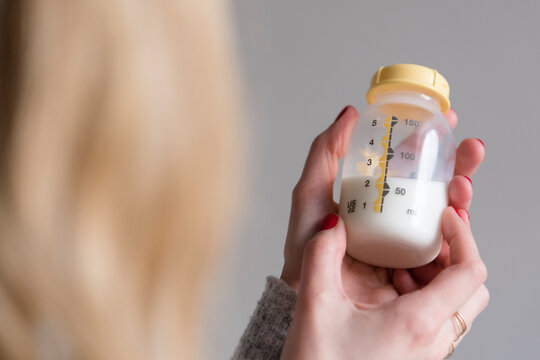 Woman holding baby bottle with milk