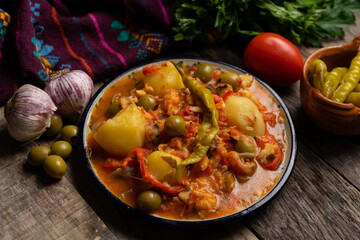 Mexican style cod called a la vizcaina on wooden background