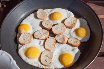 Freshly cooked fried eggs in a pan, Outdoor meal with sunlight 