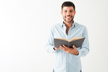 Portrait of a good-looking man happy to be reading a book