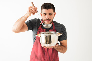 Handsome guy is smelling the food he finished cooking