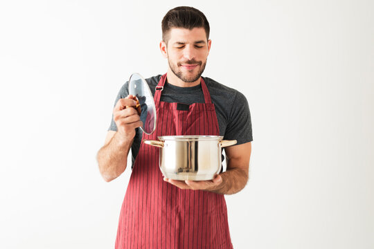 Hispanic Man Savoring The Dinner He Cooked In The Kitchen