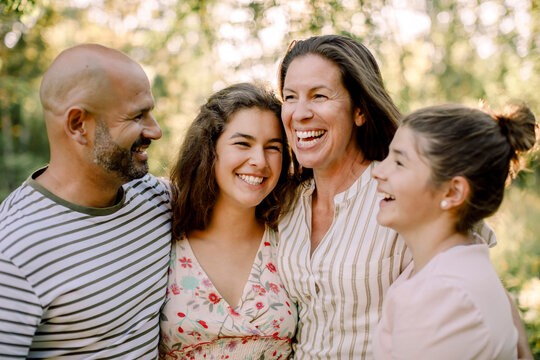 Smiling family spending time together while enjoying in yard during summer