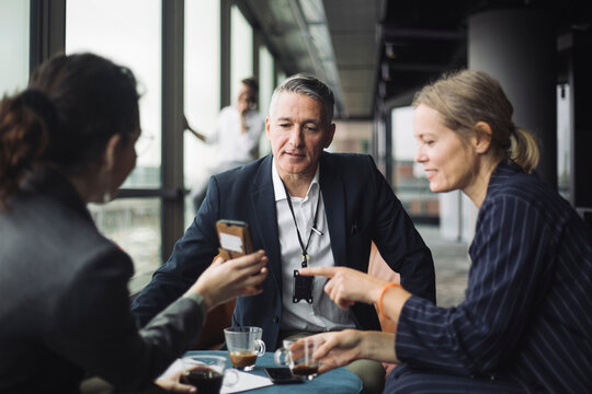 IT professionals discussing with businessman in office corridor
