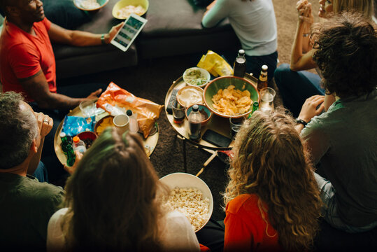 High angle view of sports fans watching TV together at night