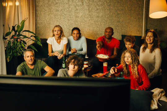 Sports fans watching TV together at night