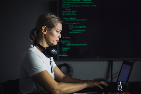 Side view of IT professional working on laptop in office