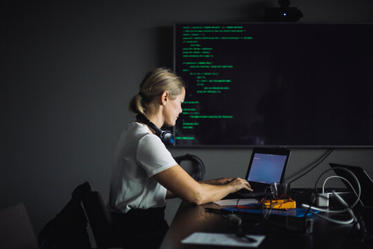 Female IT professional typing on laptop in creative office