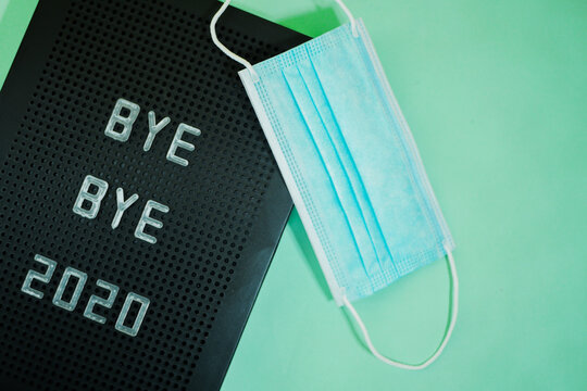 Bye Bye 2020 Written On Letter Board. Medical Face Mask. Christmas Lockdown. Copy Space. Blue Background 