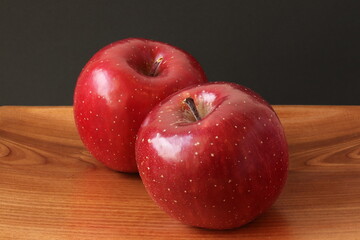 Fuji apples on a wooden plate, isolated
