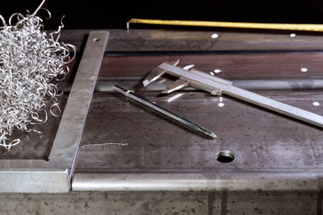 marking on a metal surface for drilling holes with a square and vernier calipers