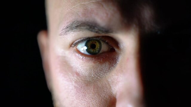 Extreme close-up of the male eye. Beautiful male with green eyes. Incredible view. Eyeball with retina, blood vessels. Macro. Play of light and shadow.