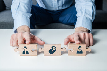 Wooden puzzle with icons of a man, woman and child. The child connects parents, creating a family.