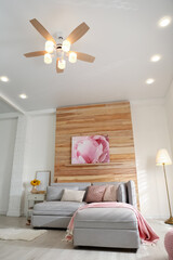 Stylish living room interior with modern ceiling fan and comfortable couch