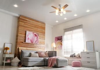 Stylish living room interior with modern ceiling fan and comfortable couch