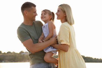 Happy parents with their child on beach. Spending time in nature