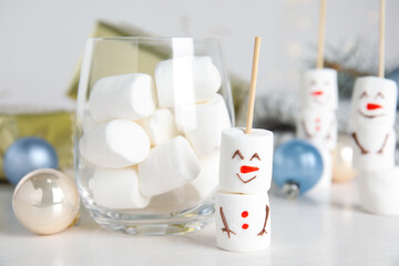 Fototapeta na wymiar Funny snowman made of marshmallows on white table