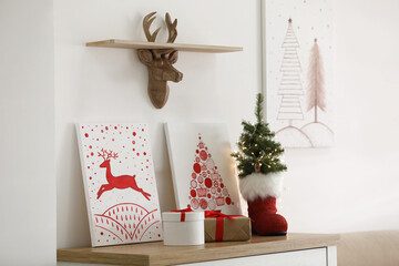 Beautiful Christmas pictures on chest of drawers indoors. Interior design