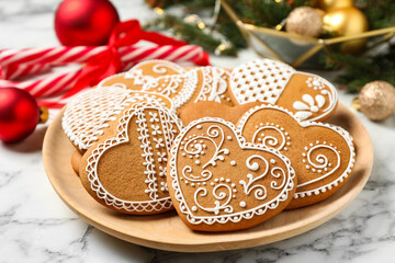 Tasty heart shaped gingerbread cookies and Christmas decor on white marble table, closeup