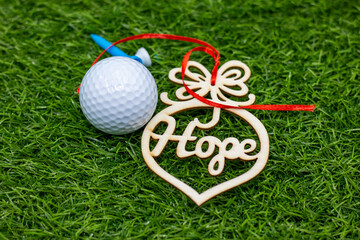 Naklejka premium Golf ball with word HOPE on green grass for best wishes on New Year Holiday
