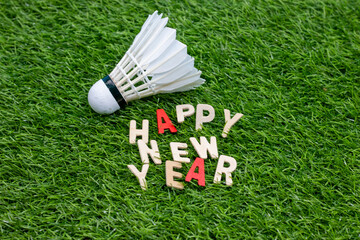 Badminton with happy New Year word are on green grass