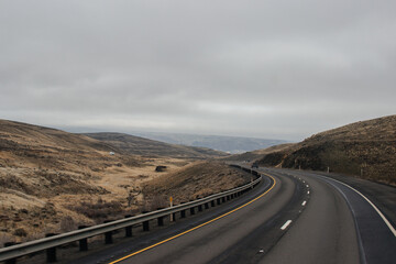 Autumn highway with trucks and cars among the mountains, bridge, road signs on a cloudy day. Oregon, USA, 02-07-2020