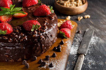 Fresh strawberry cake with chocolate topping on a table close-up