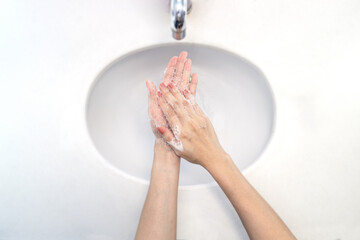 Close up of woman washing her hands for protection covid-19, Sinks top view.