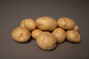 Fototapeta na wymiar Studio photo of a group of yellow potatoes. The background is grey.