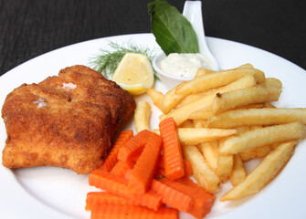 Crumbed salmon trout stuffed with cheese, served with French fries, carrots and sauce tartar