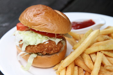 Crispy chicken burger served with French fries and ketchup