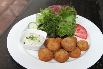 Crumbed mushrooms served with sauce tartar and salad garnish