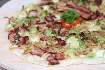 German Alsatian Pizza called Flammkuchen with bacon and onions
