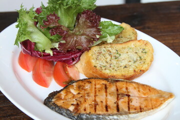 Grilled salmon with salad and garlic bread