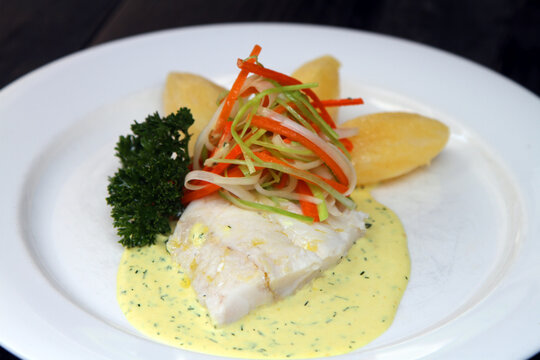 Poached Hoki fish filled on mustard cream sauce, served with boiled potatoes