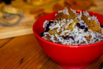 handmade preparation of treats for traditional Orthodox Christmas - rice pudding with fruits, cranberries, honey, nuts, Church candles