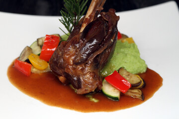 Lamb shank on sauteed vegetables served with wild garlic potato mash and gravy